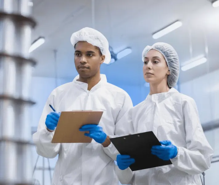 two food safety auditors conducting an internal inspection in a food manufacturing facility following iso 19011 auditing principles